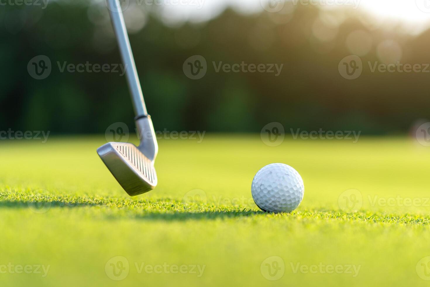 Golf ball with golf club on green field grass photo