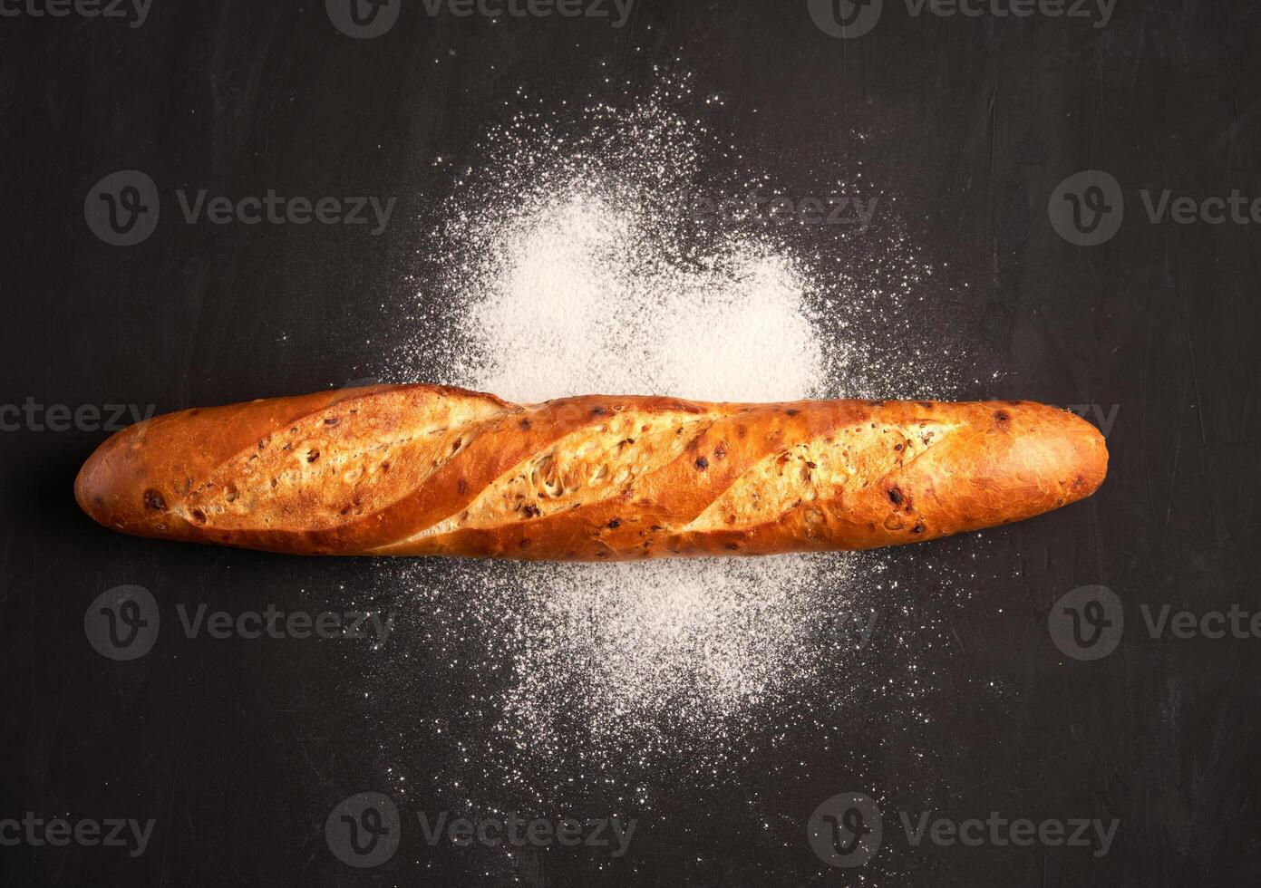 one crispy french baguettes lie on an old wooden table with free space for text photo