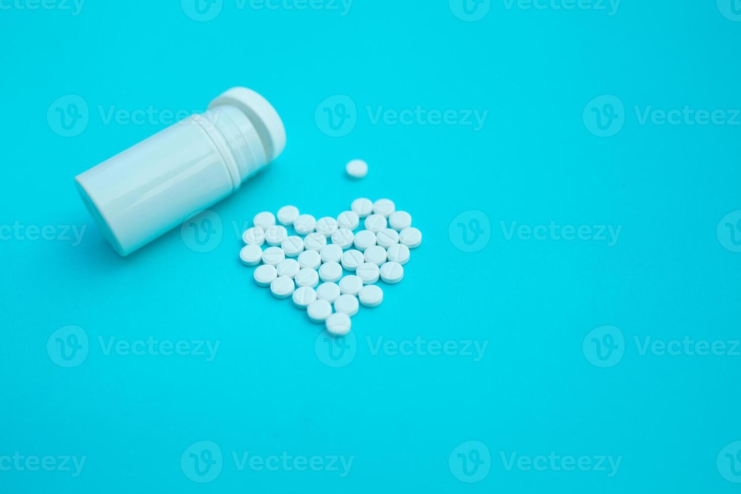 medicine, healthcare and pharmacy concept - pills and of drugs in shape of the heart photo