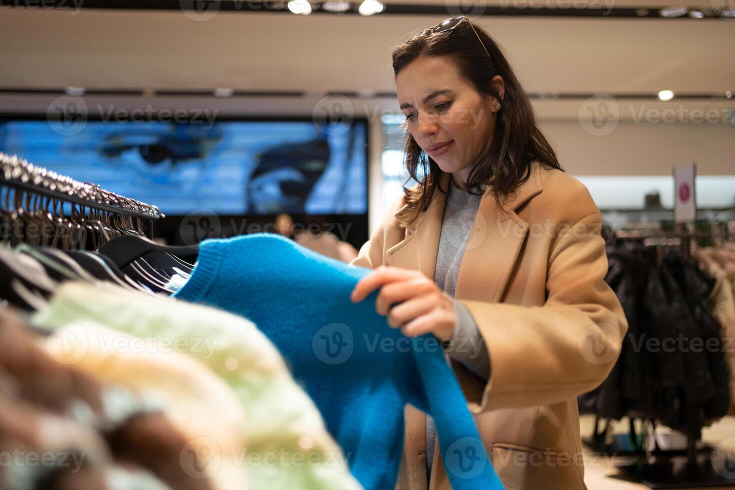 Woman dressed in stylish trench coat walks shopping mall photo