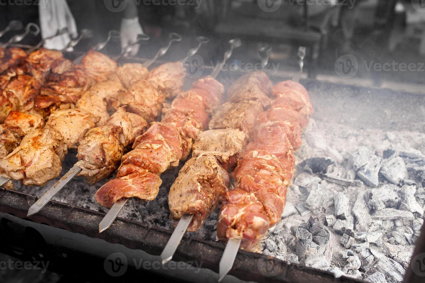 Grilled kebab cooking on metal skewer. Roasted meat cooked at barbecue. BBQ fresh beef meat chop slices. Traditional eastern dish, shish kebab. photo