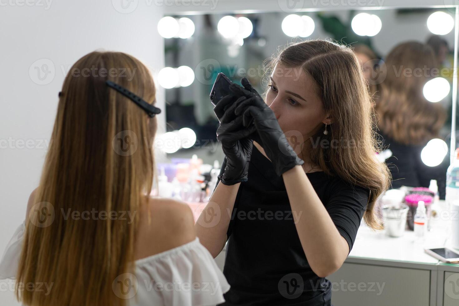 Young beautician caucasian girl holds model eyebrow correction photo