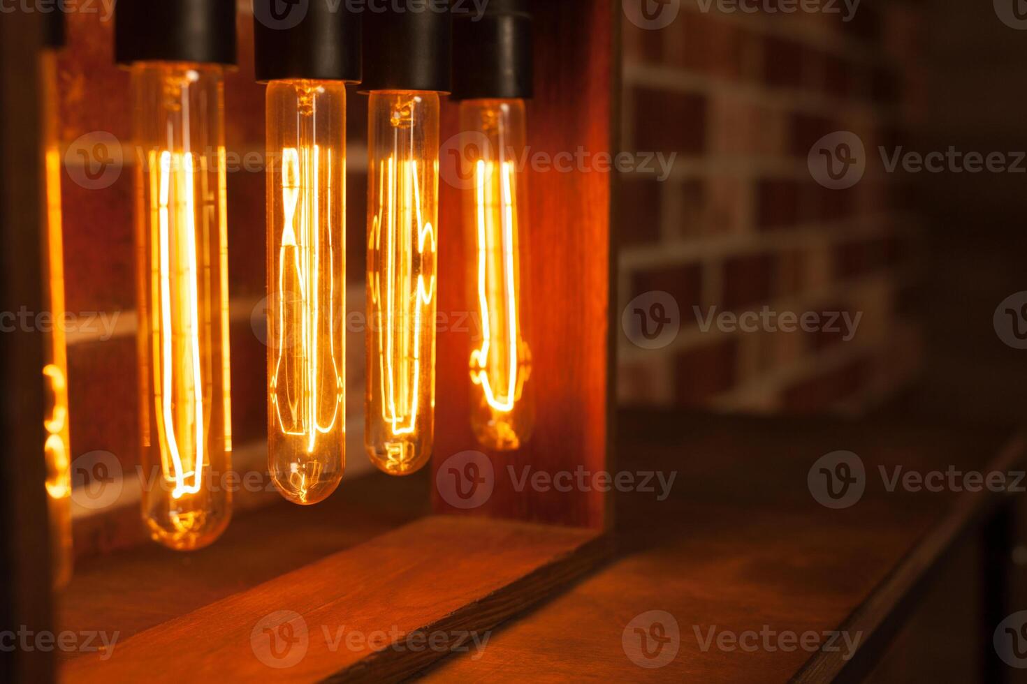 Light bulb lamp on dark red brick background with hotspot close up loft photo