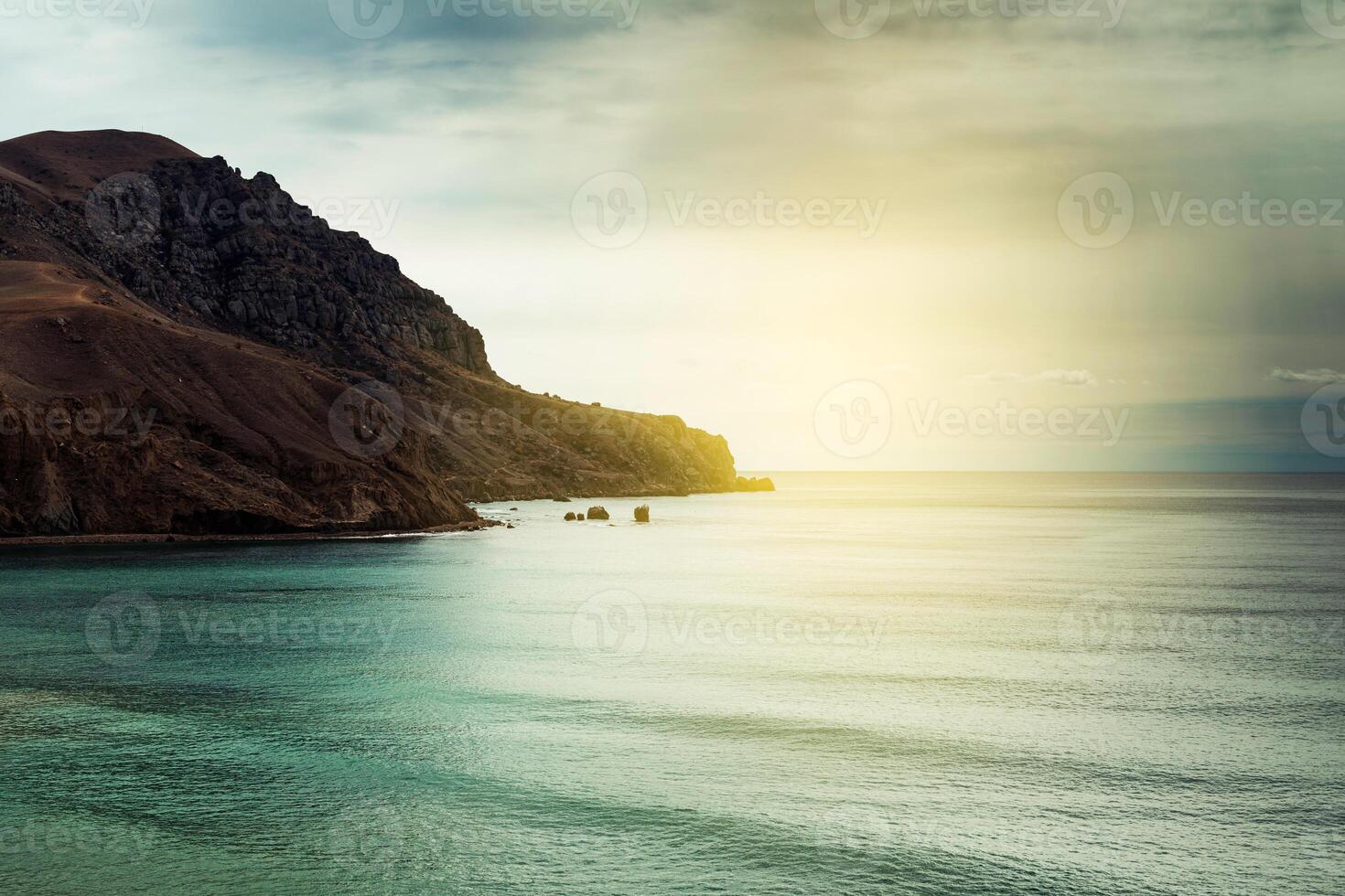Beautiful rock on sunset sea background photo