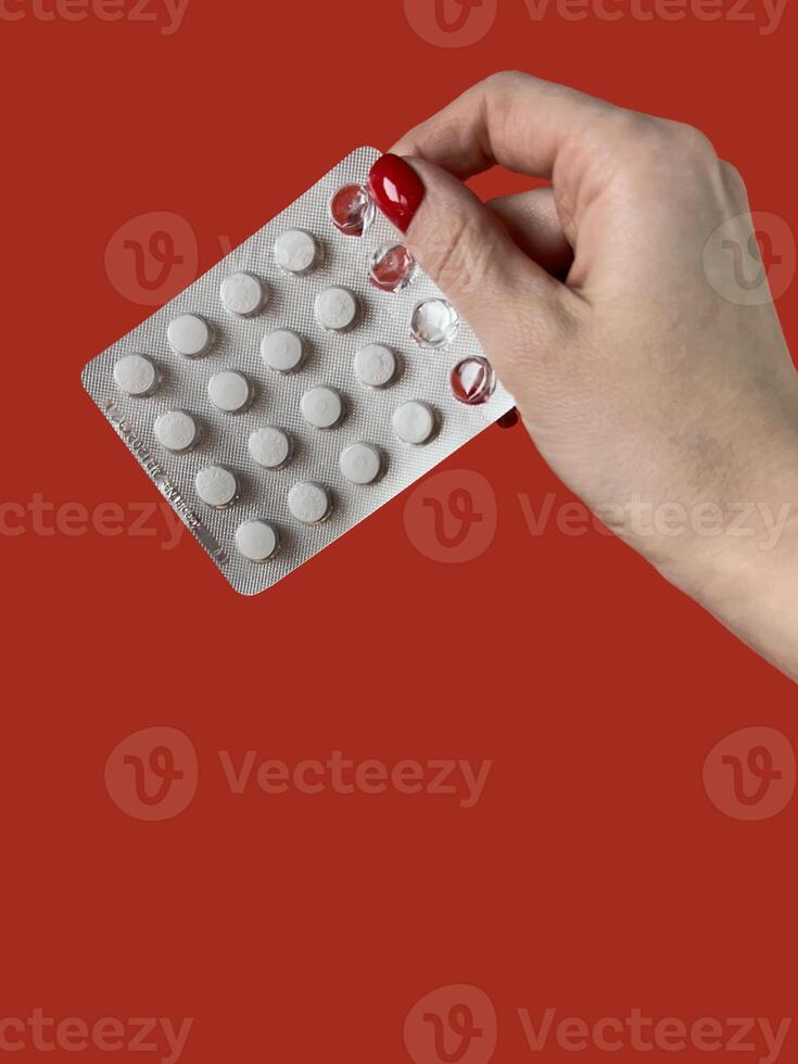 de cerca ver de ampolla paquete con pastillas en hembra mano aislado en rojo antecedentes foto