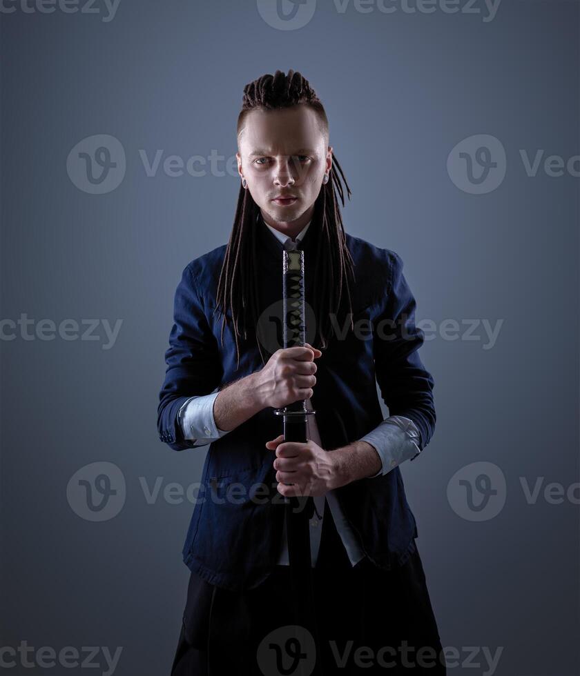 Young man holding a samurai sword. Glamour photo. photo