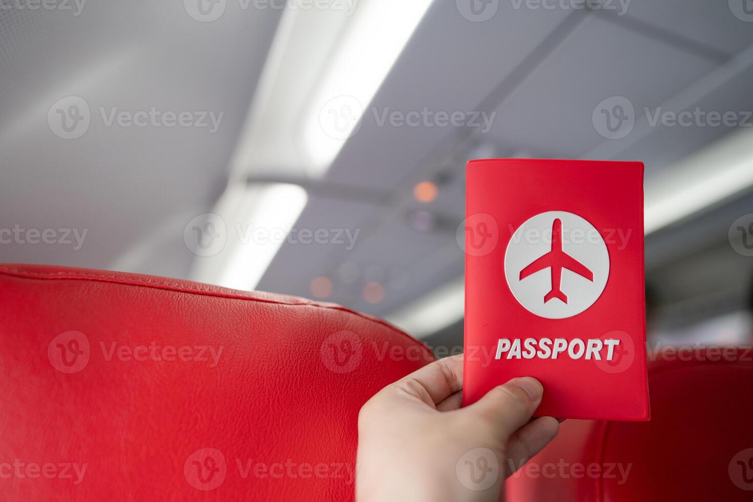 Hand holding passport in the airplane cabin. photo