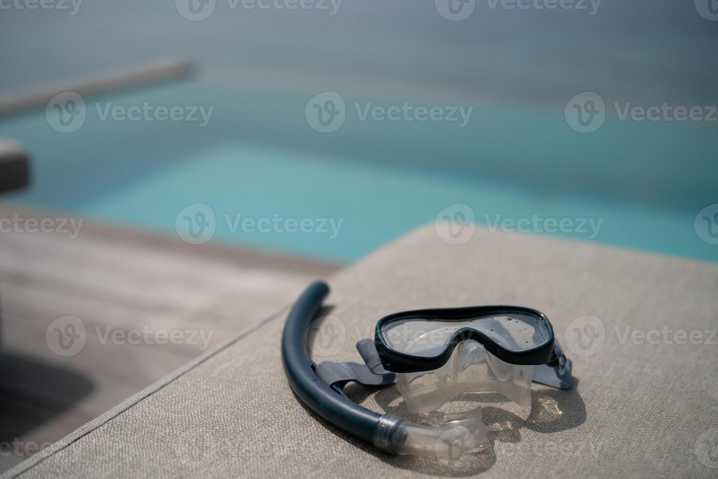 Snorkel and swimming mask lie on a gray pad background. photo