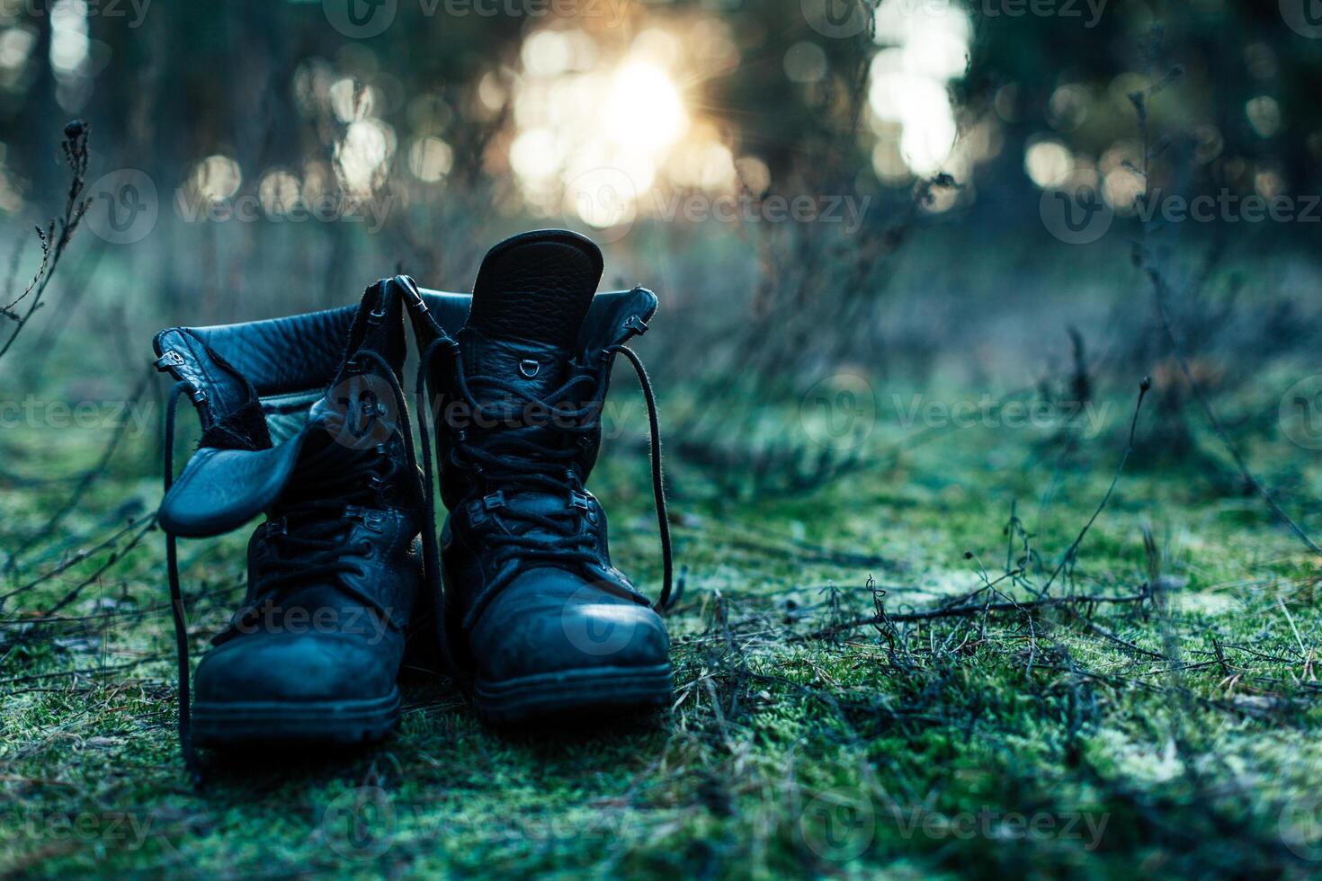 hiker old black boots standing on grass Hard travel concept photo