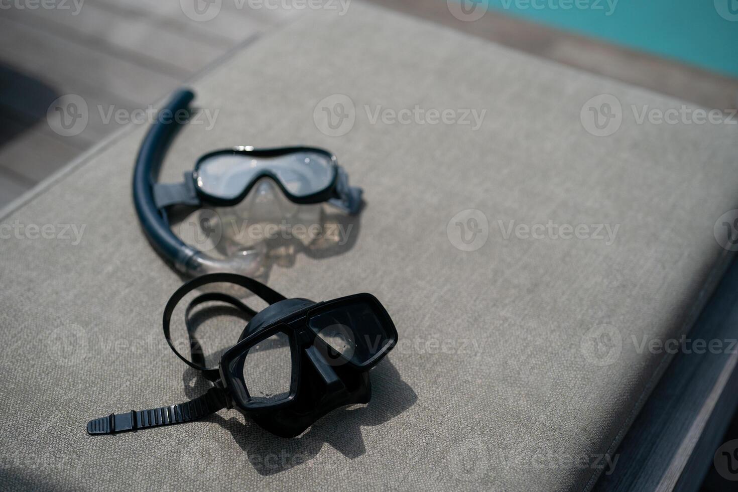 Snorkel and swimming mask lie on a gray pad background. photo