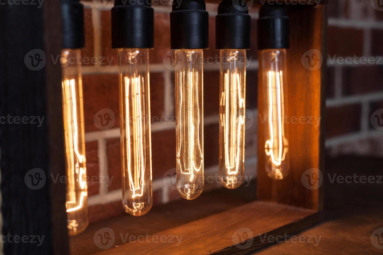 Light bulb lamp on dark red brick background with hotspot close up loft photo