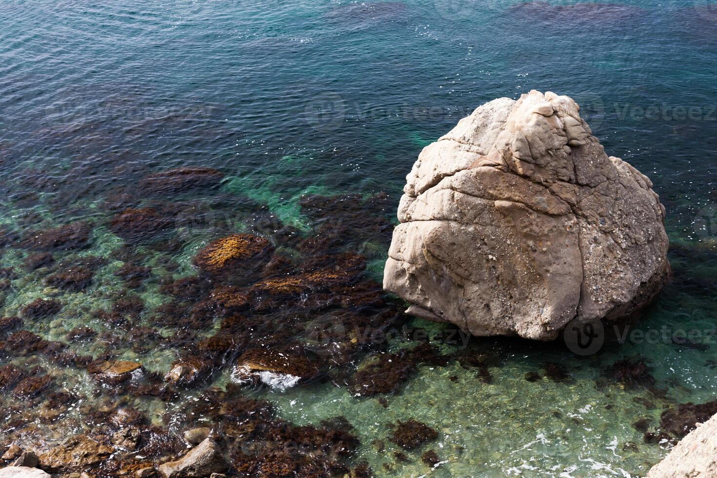 big stone in the transparent sea water photo