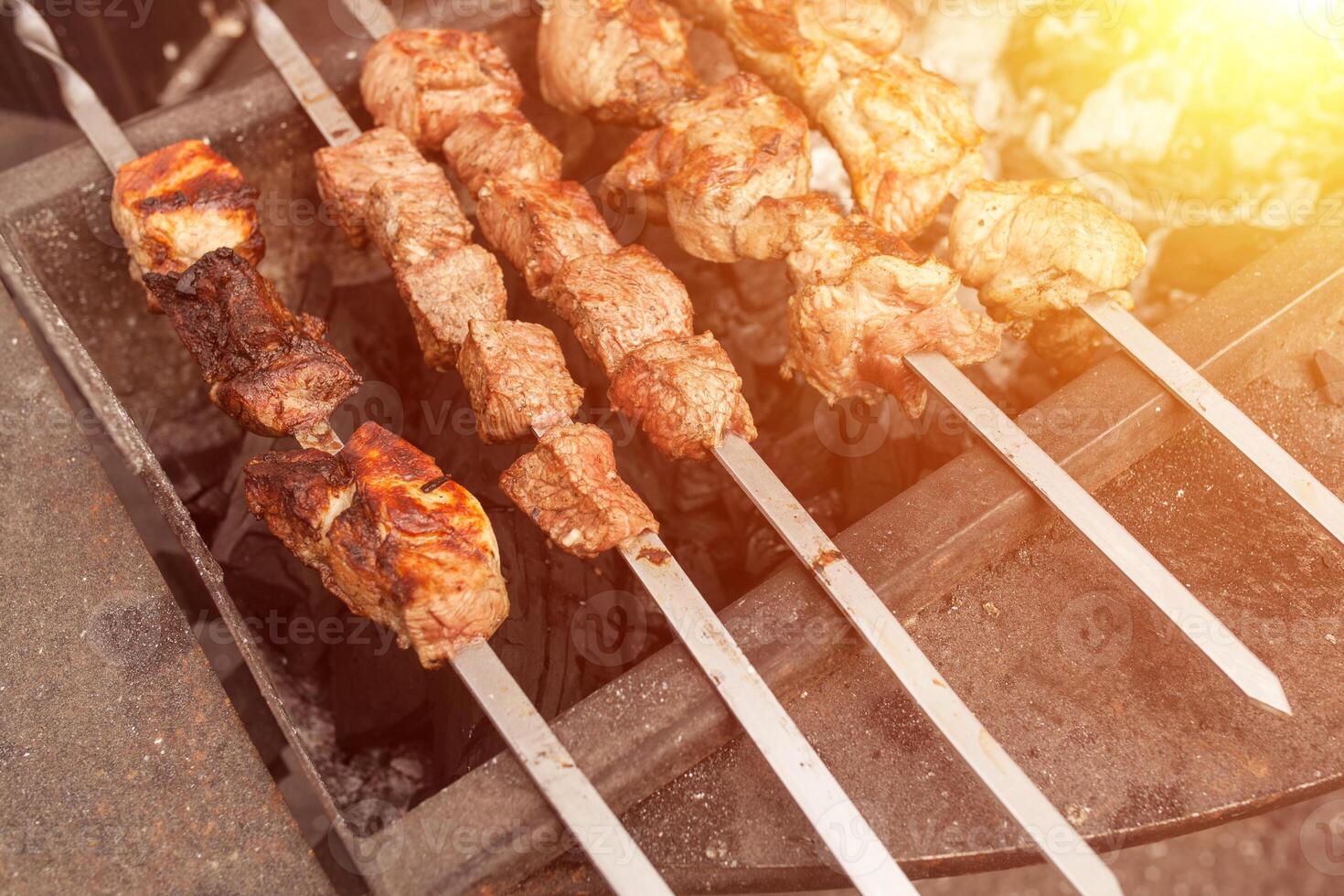 Grilled kebab cooking on metal skewer. Roasted meat cooked at barbecue. BBQ fresh beef meat chop slices. Traditional eastern dish, shish kebab. photo