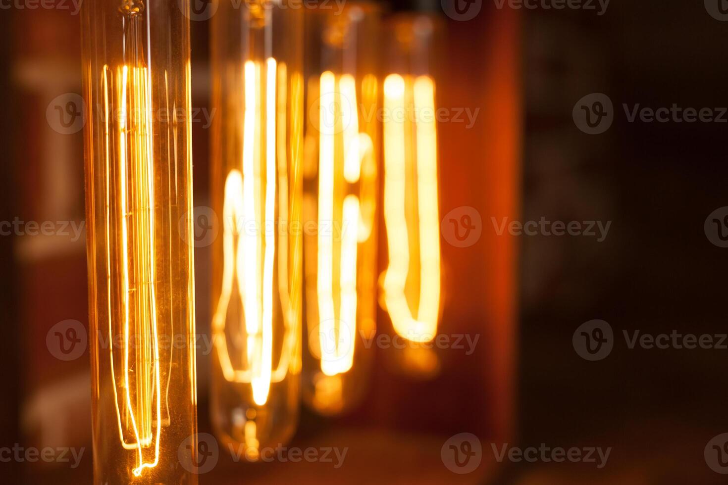 Light bulb lamp on dark red brick background with hotspot close up loft photo