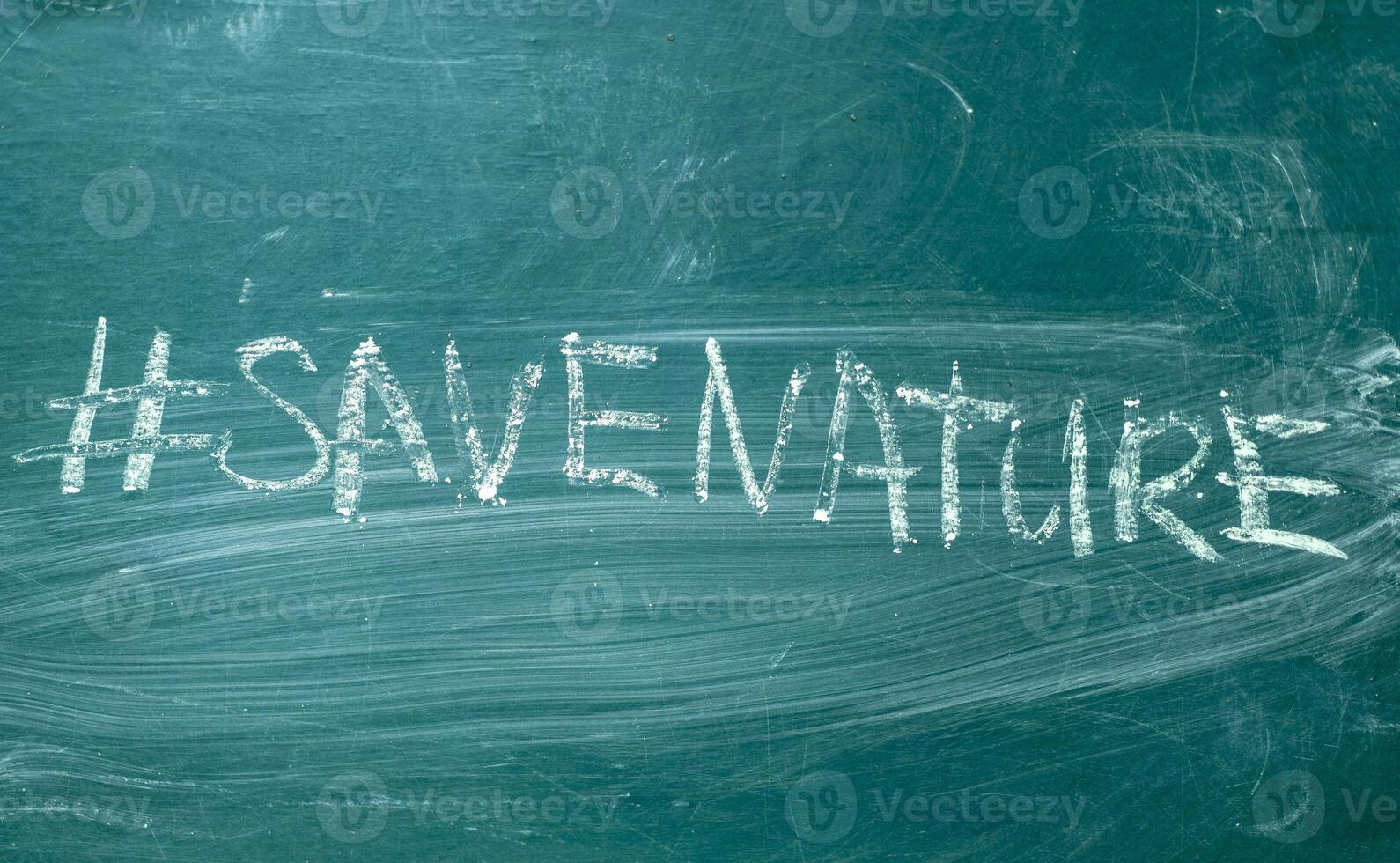 Save the nature hashtag it handwritten with white chalk on a green blackboard photo