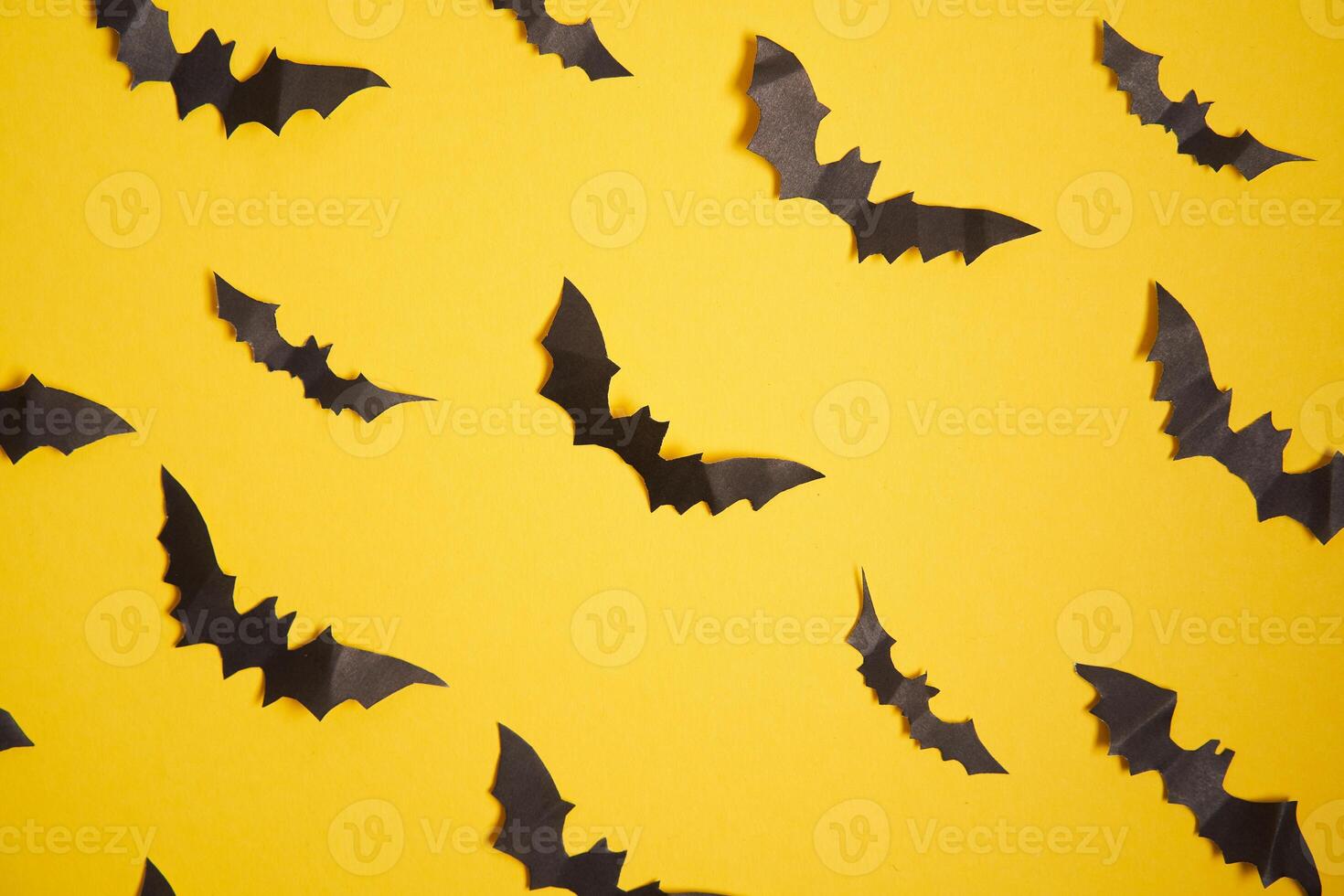 Halloween decoration concept black paper bats yellow cardboard background photo