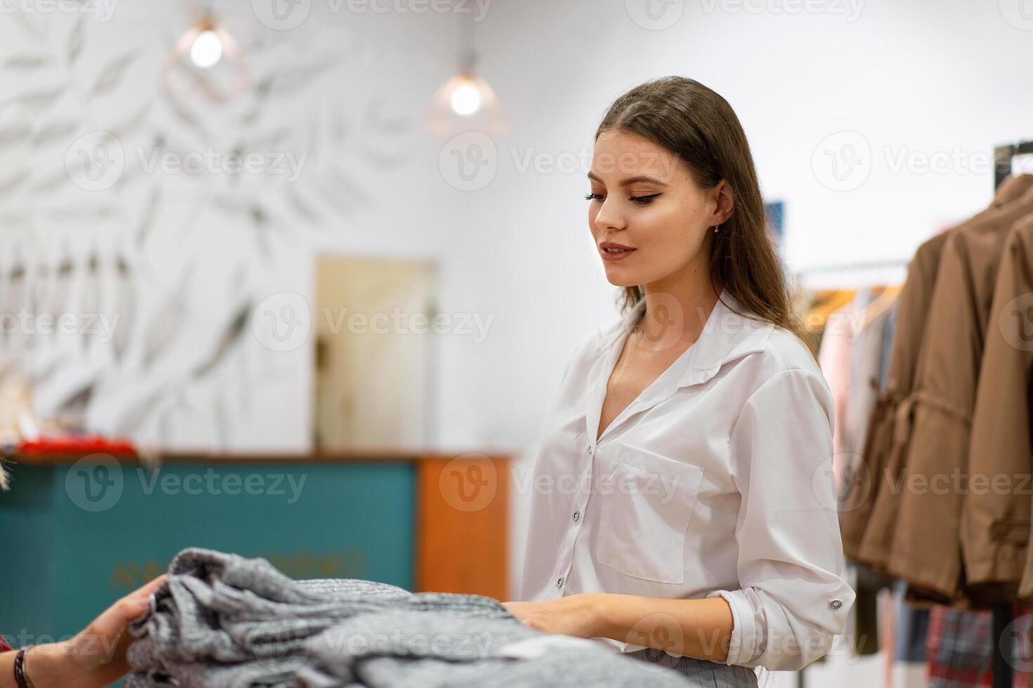 One caucasian women in a fashion boutique choose clothes buy for autumn season. photo