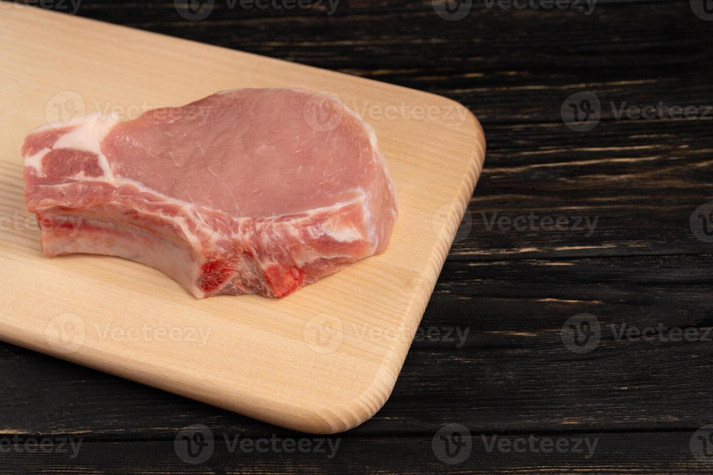 Top view of one pieces raw pork chop steaks on a cutting board. photo