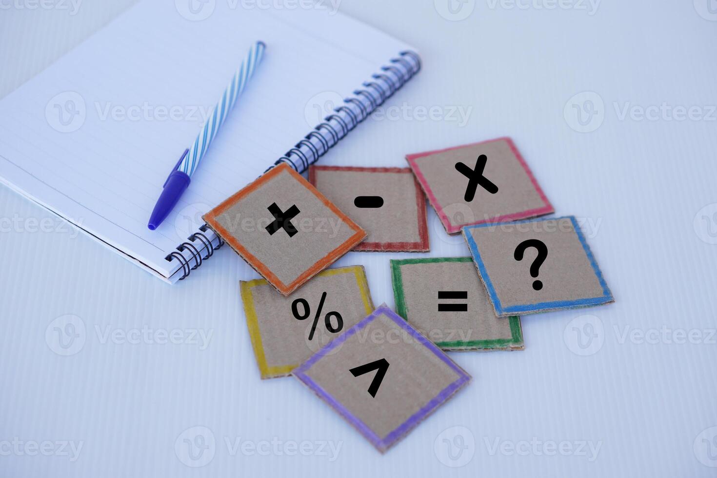 Square paper cards with math symbol signs set, paper notebook and pen. Concept, education material.  Math teaching aid for calculate lesson or playing game. photo