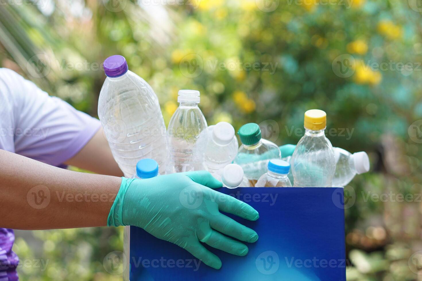 Hand holds used plastic bottle to put in junk bin for recycling. Concept, sorting garbage campaign before throw away for reuse or recycle. Environment conservation. Eco friendly activity. photo