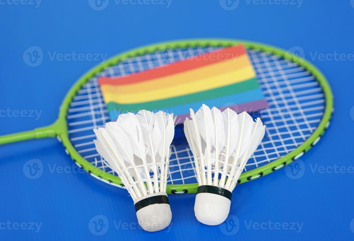 Badminton shuttlecocks, rainbow colors flag on racket. Concept, sport, exercise, recreation activity for good health. Popular sport for all genders and LGBTQ worldwide. photo