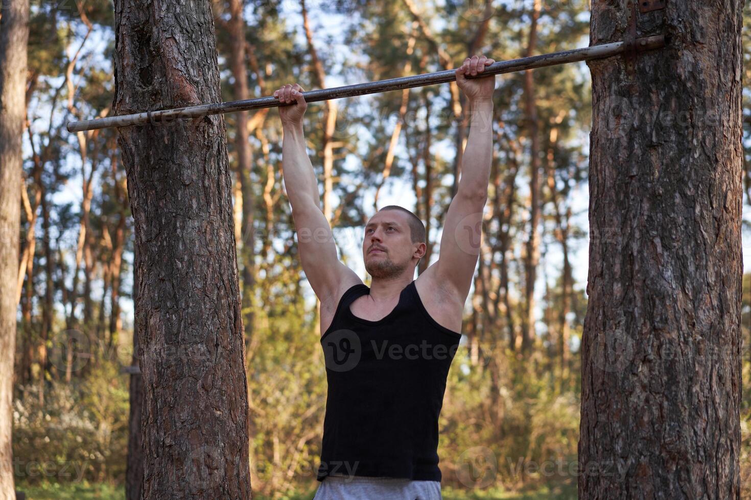 Handsome caucasian men pull-up outdoor workout cross training morning Pumping up arm exercising sports ground nature forest photo