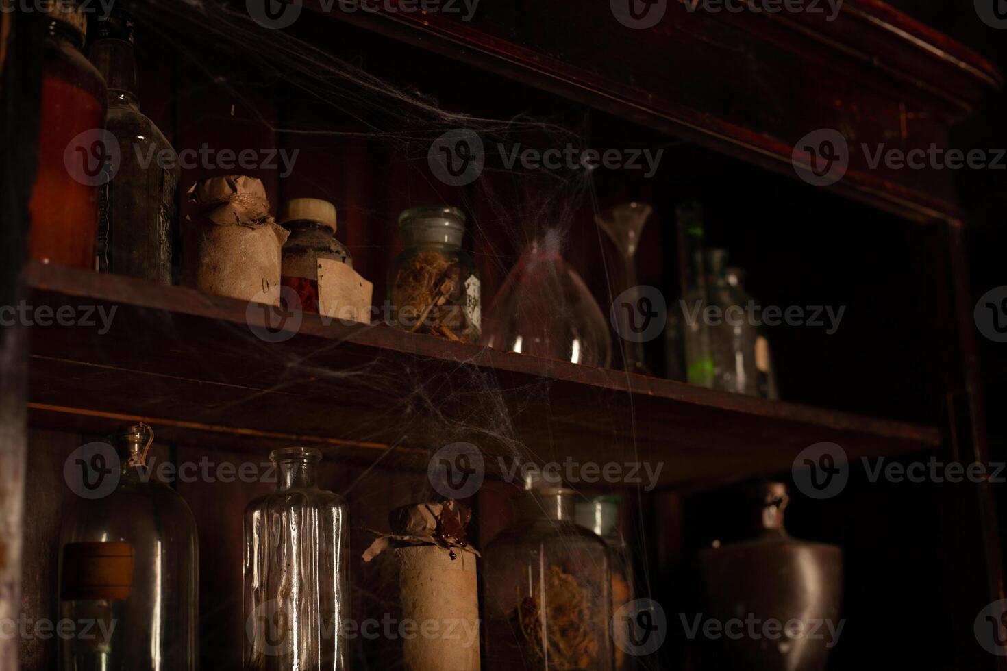 Halloween background Shelves with alchemy tools Skull spiderweb bottle with poison candles photo