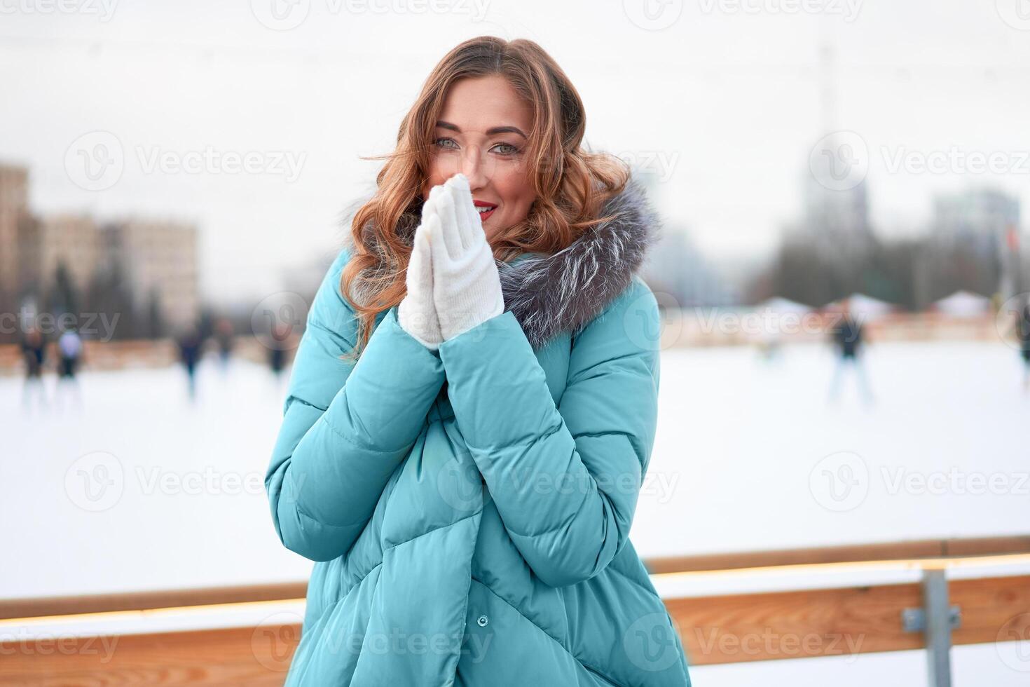 hermosa encantador de edad mediana niña con Rizado pelo calentar invierno chaquetas soportes hielo pista antecedentes pueblo cuadrado. foto