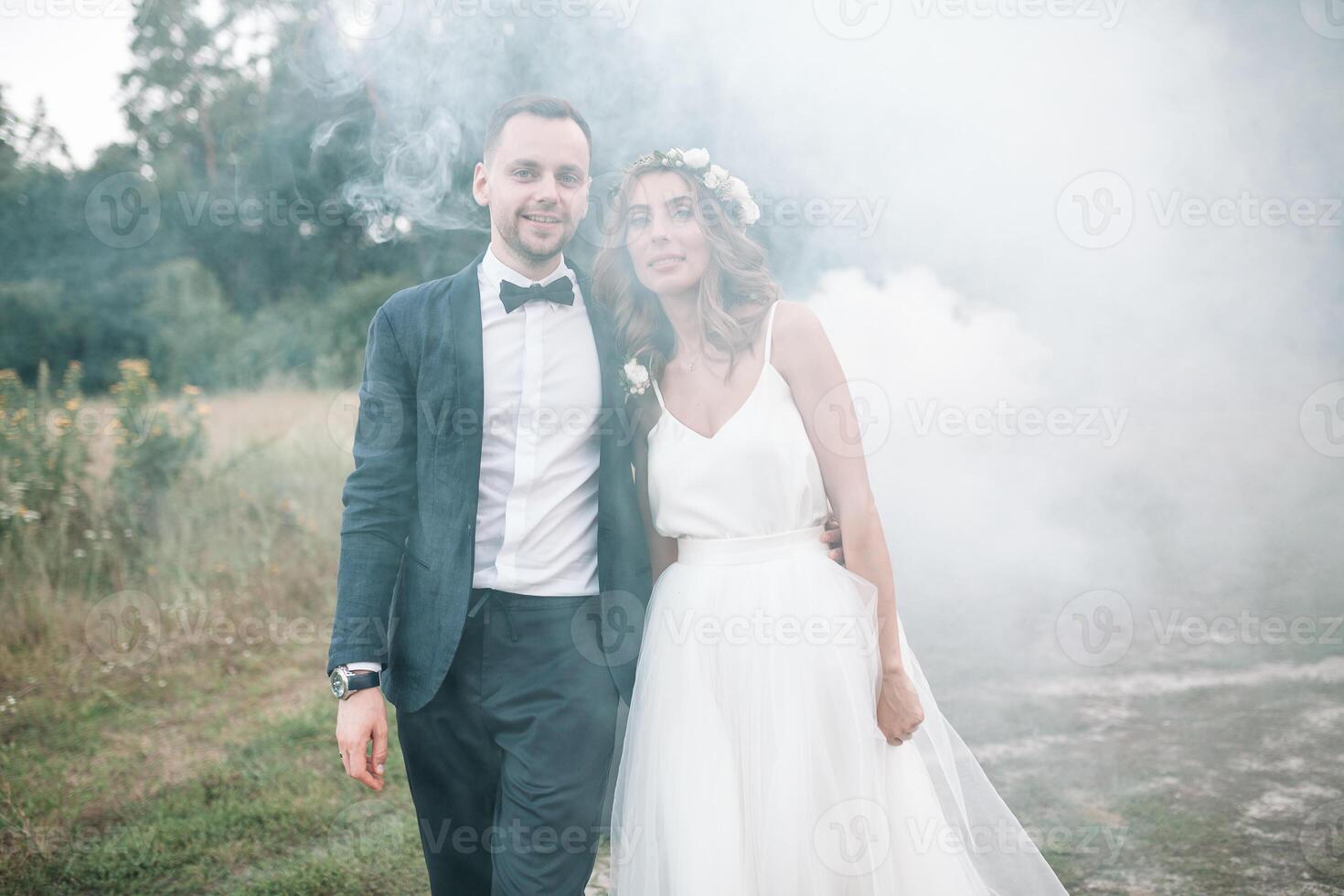 Beautiful bride and groom. Wedding ceremony in nature. Smoke bombs. photo