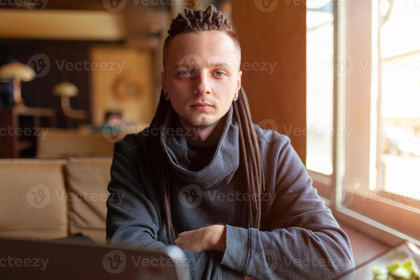 Young Businessman with dreadlock having doing his work in cafe with laptop. photo