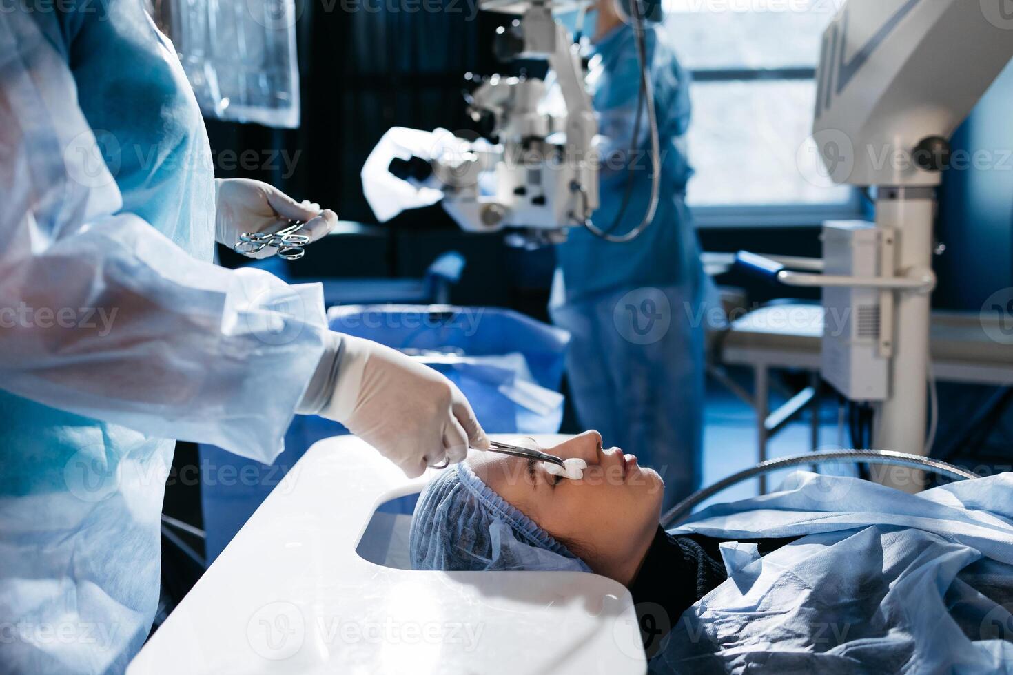 Hands of ophtalmology surgeons and assistants with ophtalmological surgery tools during surgical treatment. Eye disinfection. Doctor wears gloves photo