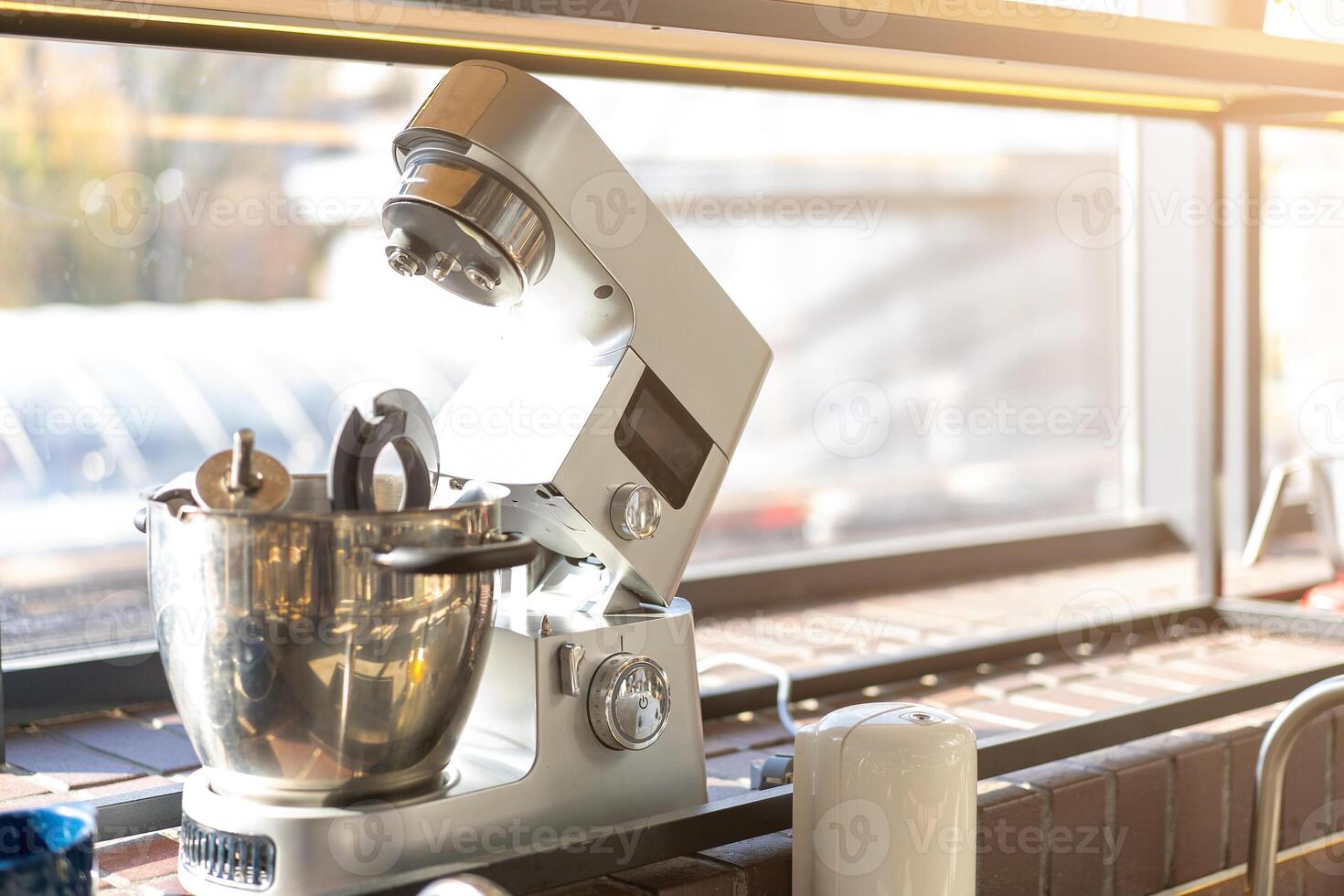 Disassembled multifunctional food processor in the kitchen by the window photo