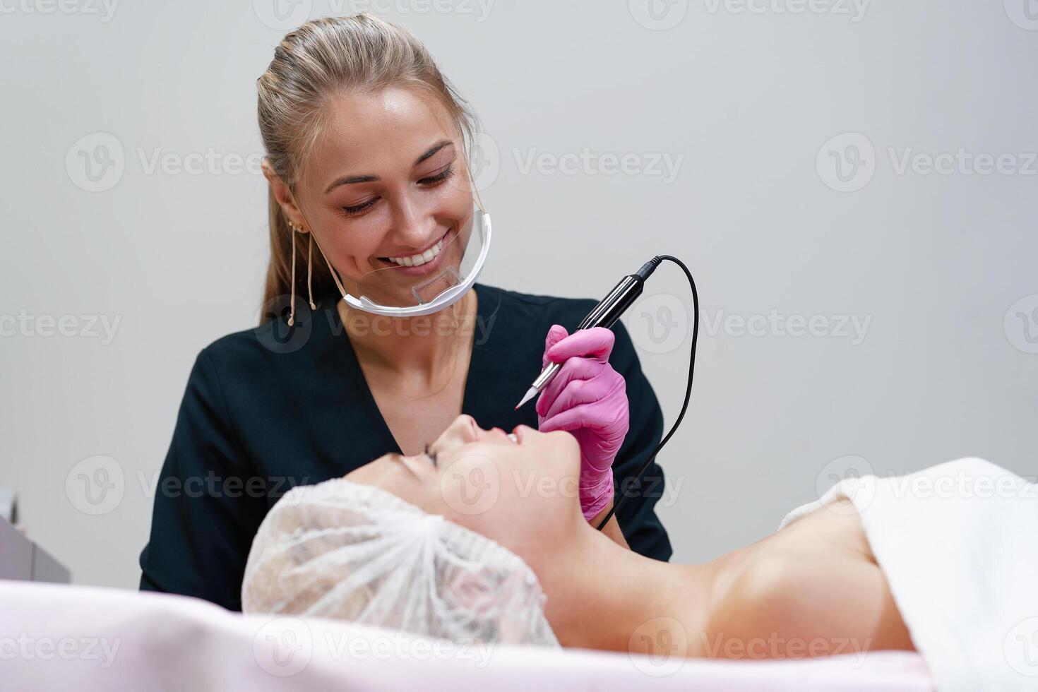 Cosmetology cabinet client lies on couch. Beautician applies marking on eyebrows. photo