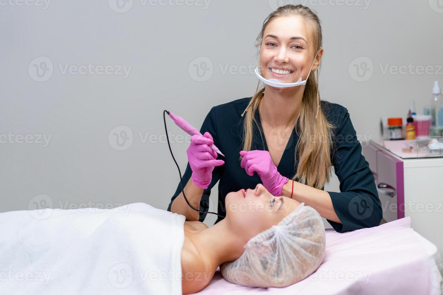 Cosmetology cabinet client lies on couch. Beautician applies marking on eyebrows. photo