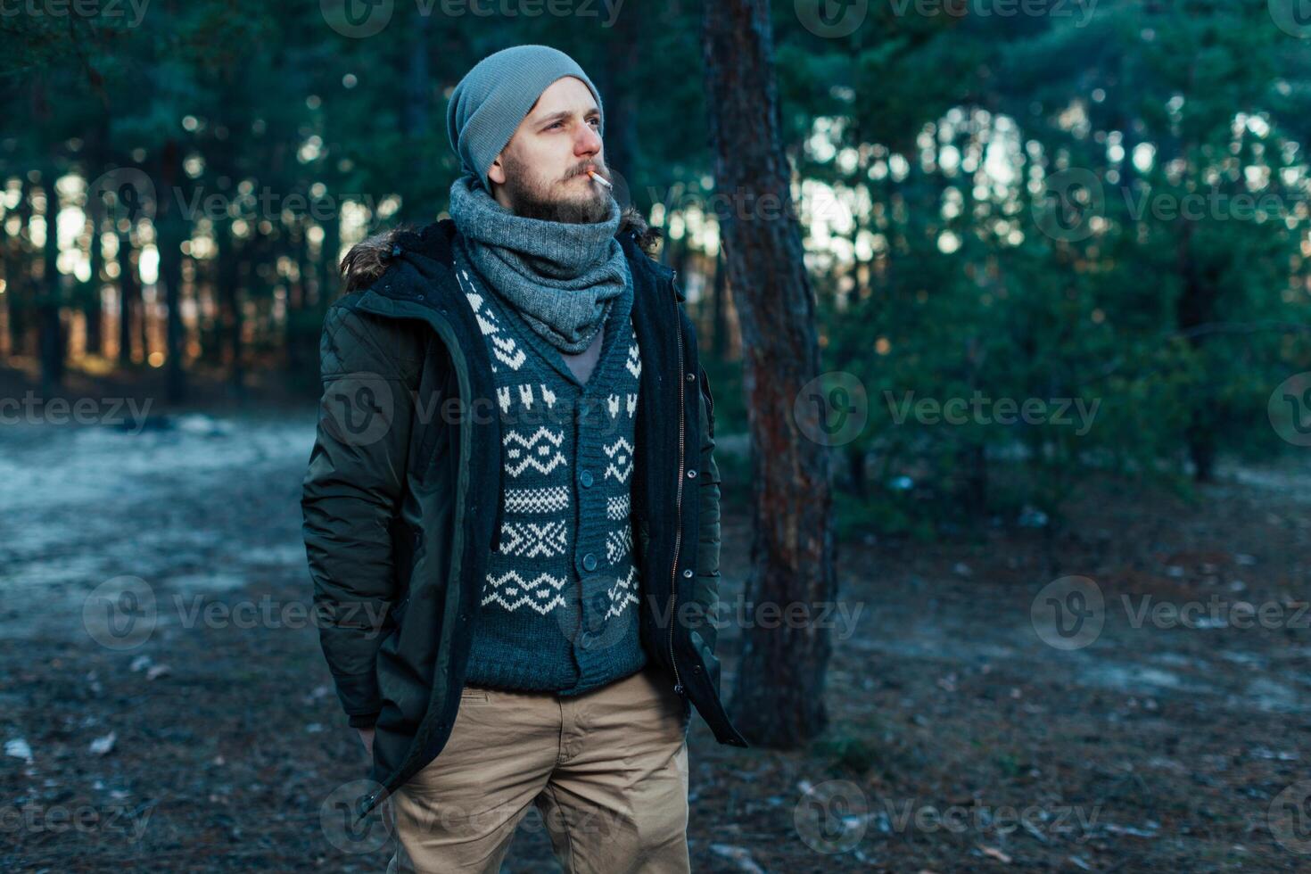 Portrait brutal bearded hipster man in the forest photo