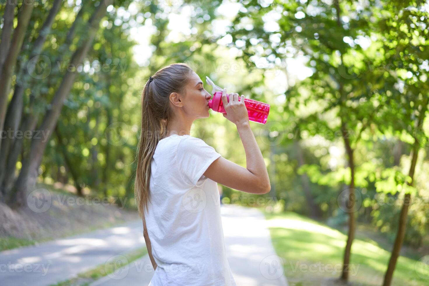 Woman drink water red bottle after morning workout. photo