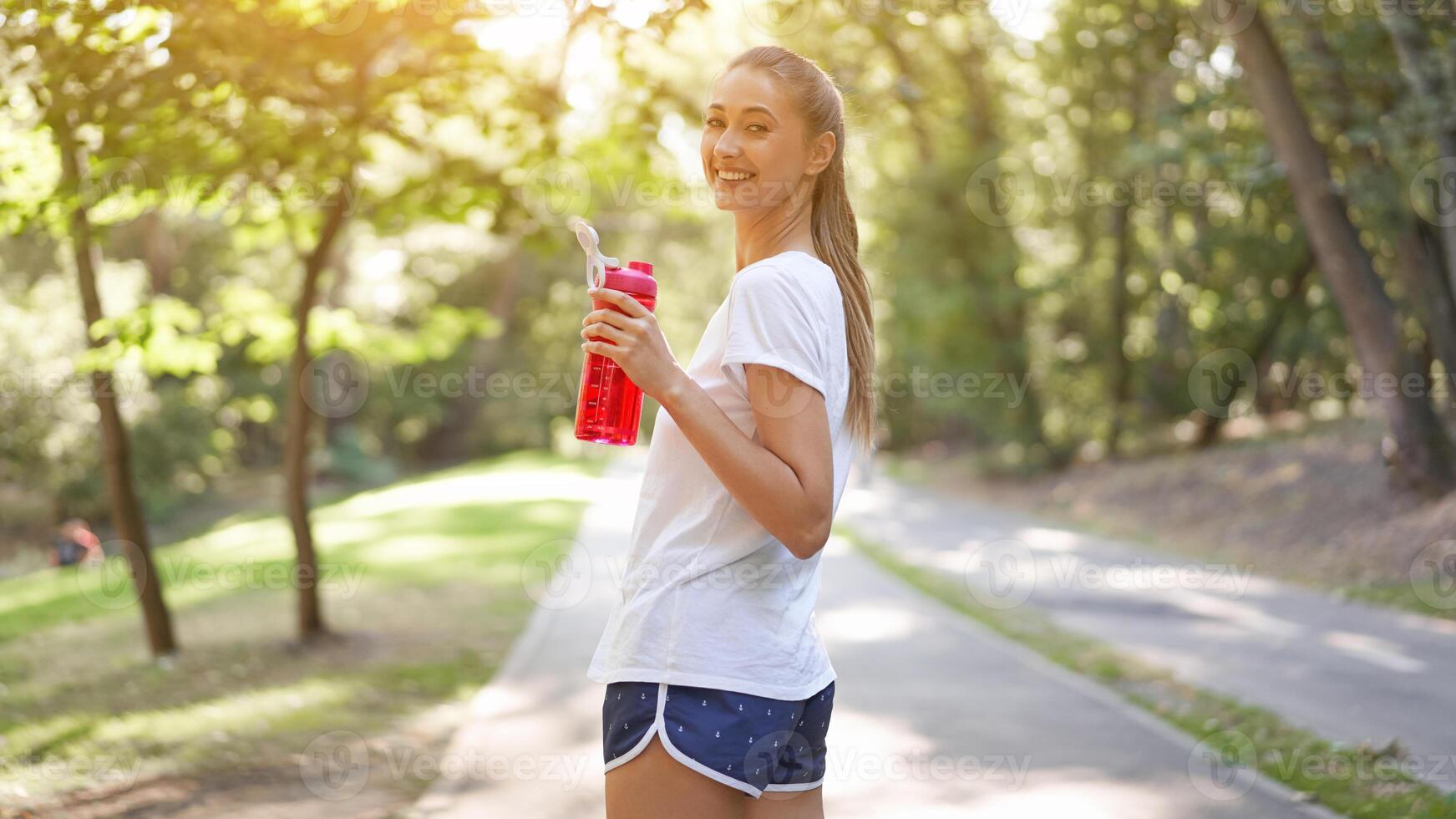 Woman drink water red bottle after morning workout. photo