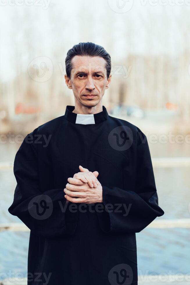 Portrait of handsome catholic priest or pastor with collar photo