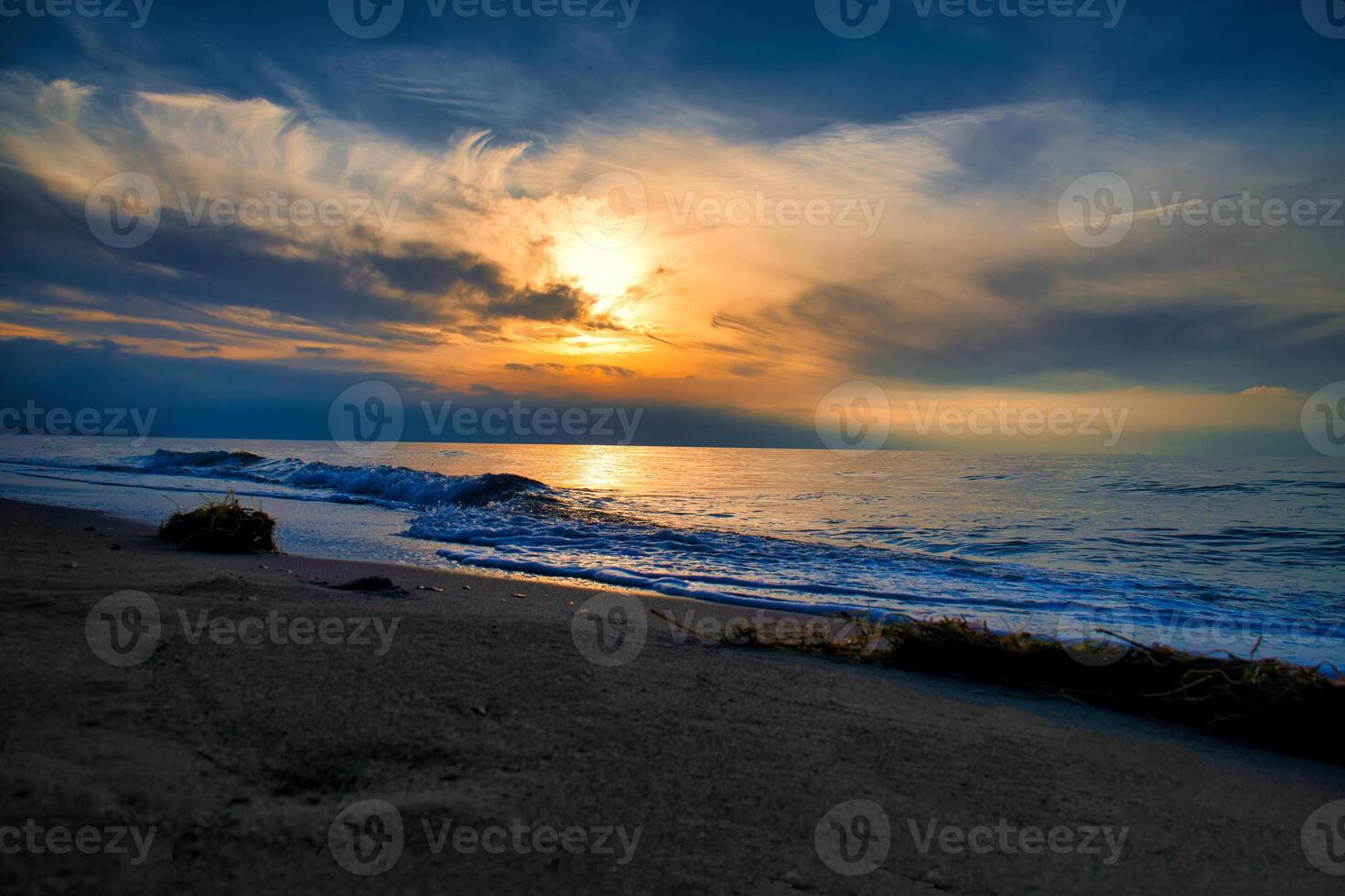 Sunset, illuminated sea. Sandy beach in the foreground. Light waves. Baltic Sea photo