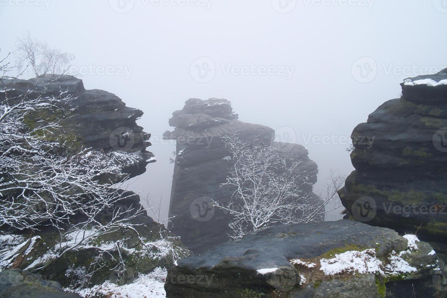 On the large Zschirnstein in fog. Rock covered with snow. Viewpoint Elbe Sandstone Mountains photo