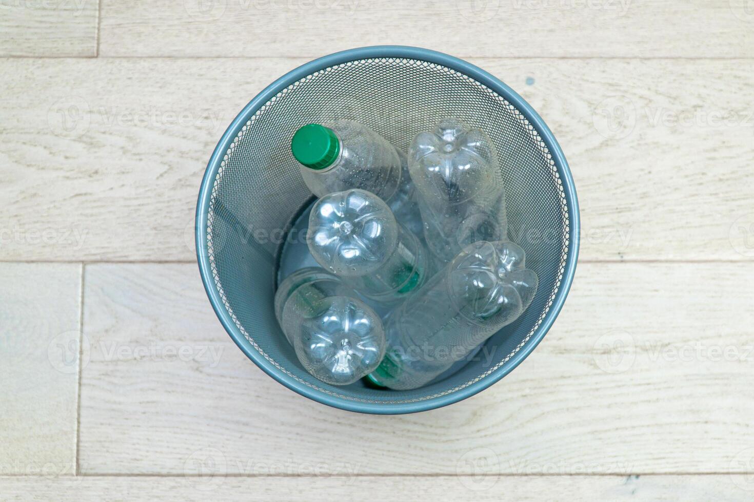 Five different plastic bottles in the office trash can. Ecology and recycling of waste from various raw materials photo