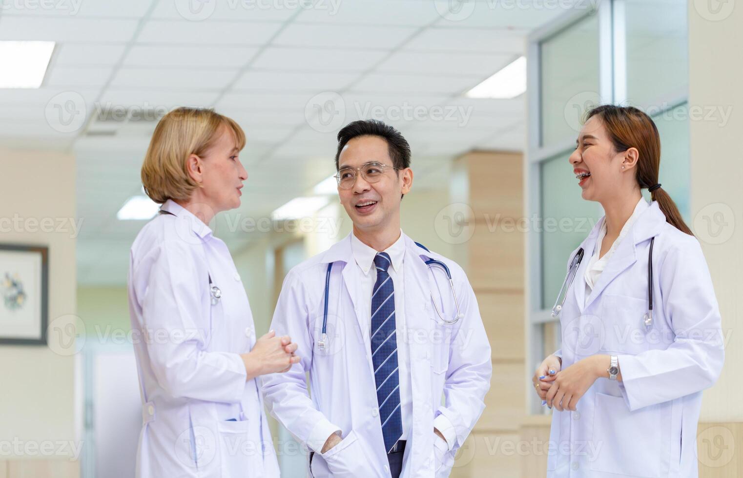 Medical team discussing in the corridor at hospital, team of mixed-races doctors, Group of multi ethnic medics, men and women talking and having discussion photo