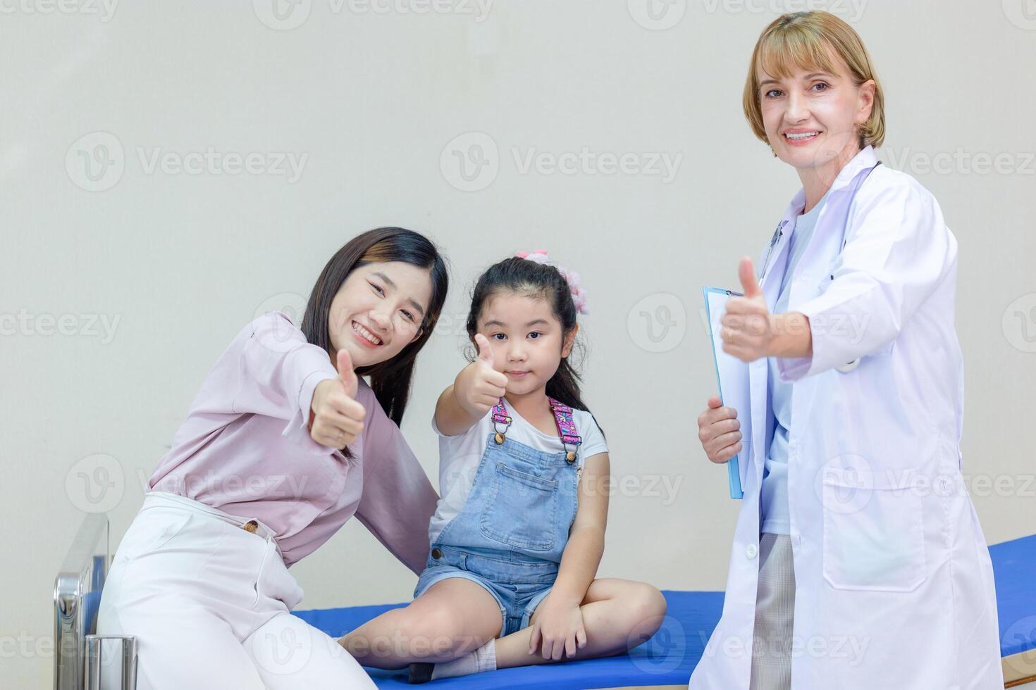 Young mother and child at a medical checkup at hospital or clinic, Female doctor talking with daughter and mother in hospital photo