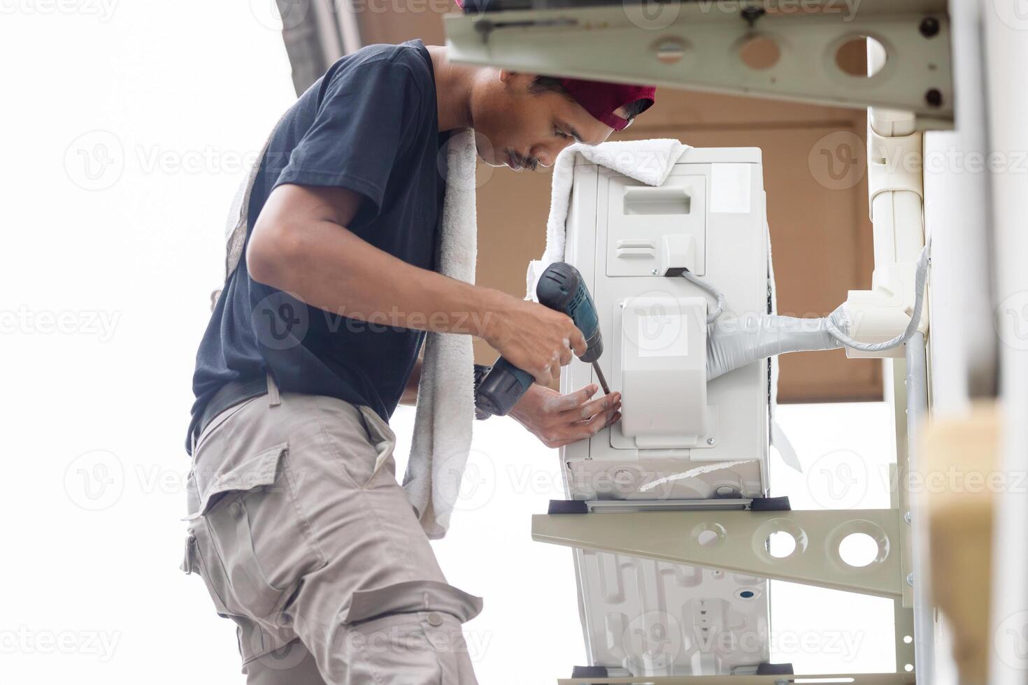 técnico hombre utilizando un destornillador a reparar moderno aire acondicionador, reparando y mantenimiento, mantenimiento, y reparando conceptos foto