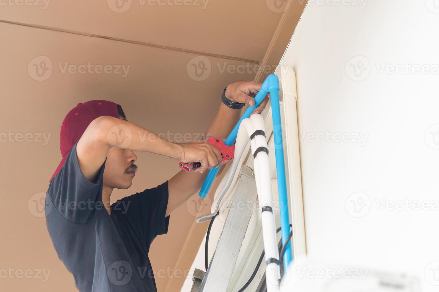 Technician man install water drain pipe air conditioning system, repairing servicing and install new air conditioner concepts photo