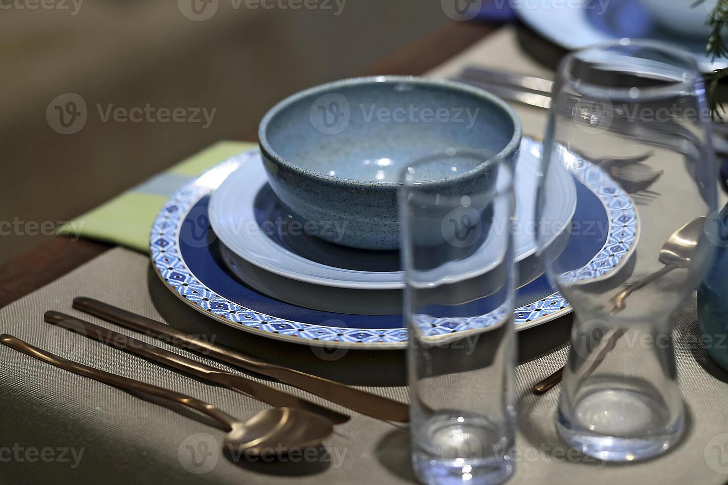 setting up sophisticated tables with various types of bowls, plates and glasses photo