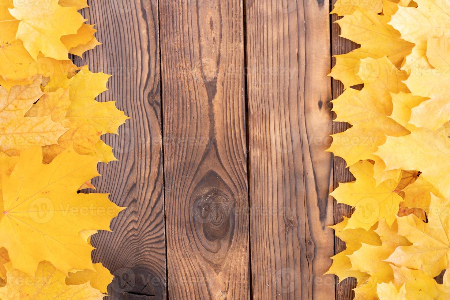 Autumn leaves frame on wooden background top view Fall Border yellow and Orange Leaves vintage wood table Copy space for text. photo