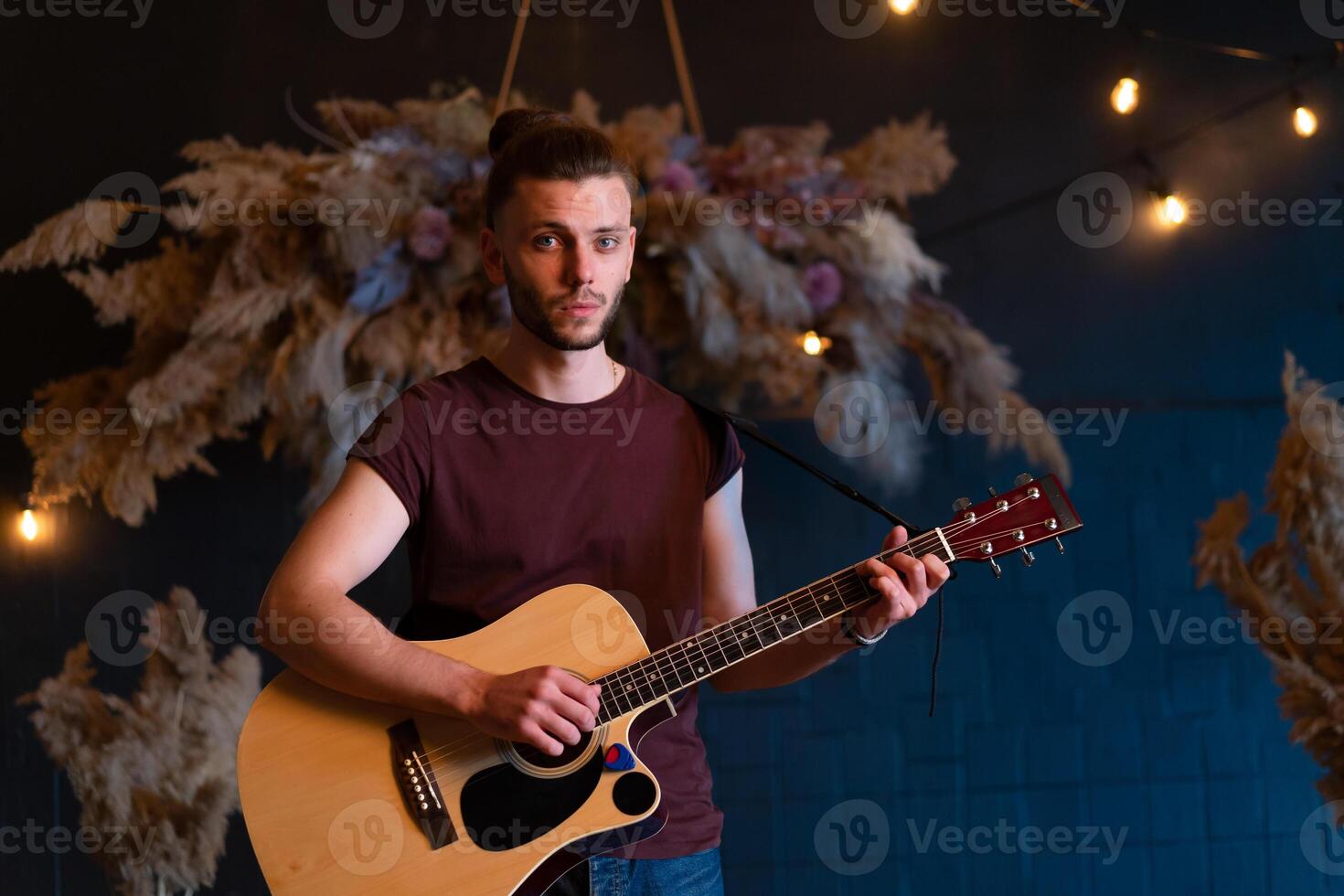 Male musician playing acoustic guitar. Guitarist plays classical guitar on stage in concert photo