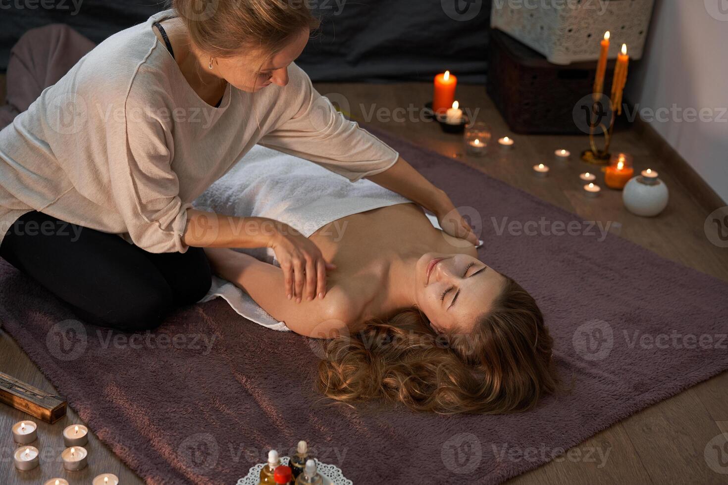 Relax and enjoy in spa salon, getting massage by professional masseur. Woman lying with naked back relax on floor blanket photo