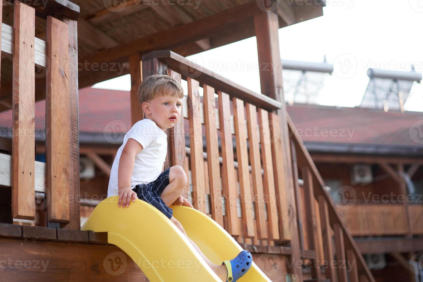 pequeño chico diapositiva jugando patio de recreo activo infancia disfrutar verano foto